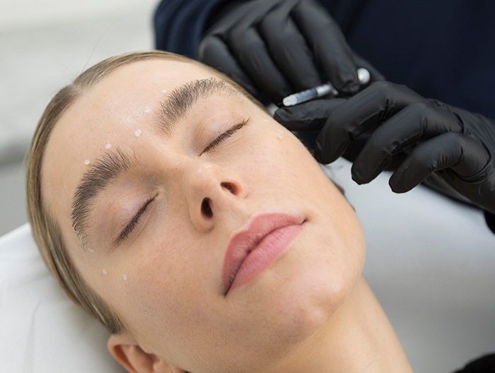 A woman having Anti Wrinkle treatment injections to the side of her eye