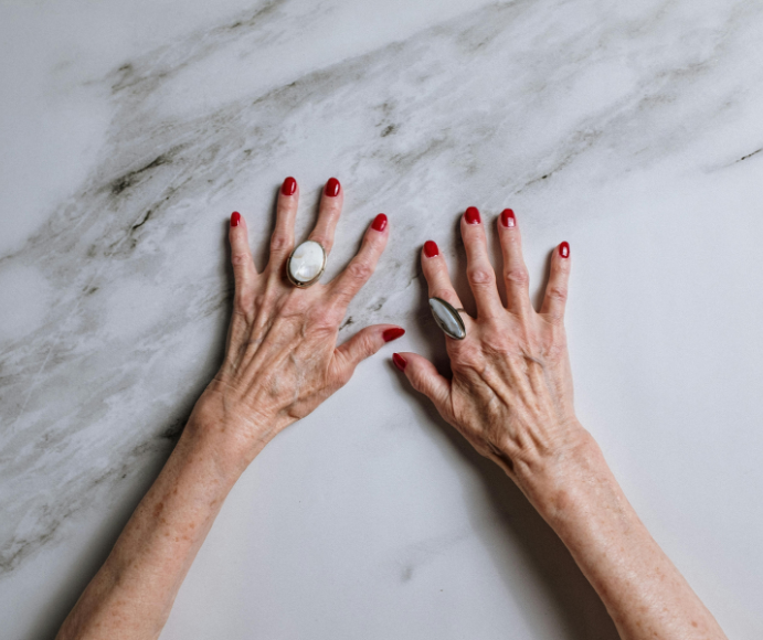 Close up of a woman's arms and hands on a marble surface